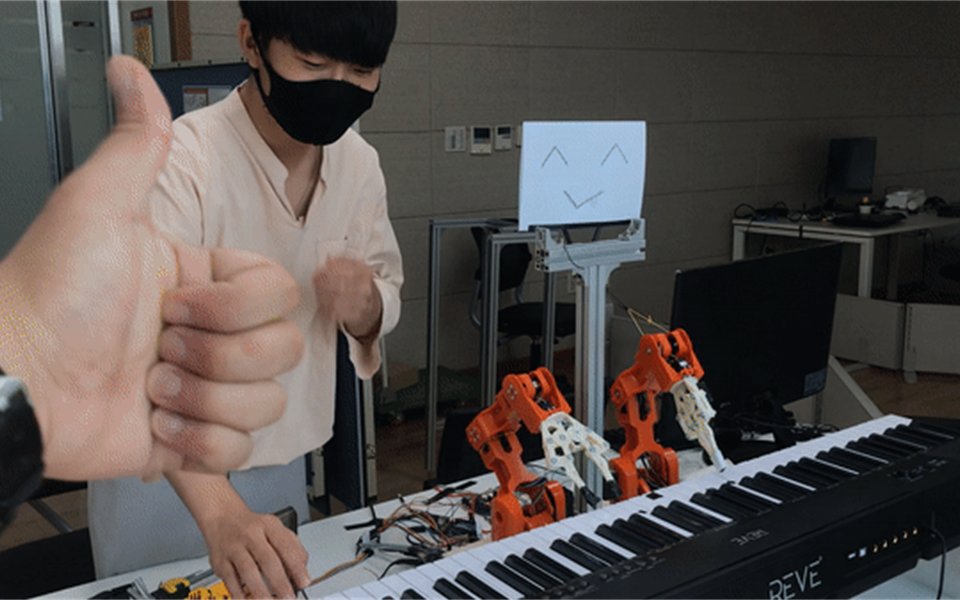 Robotic hands playing a keyboard with a human performer